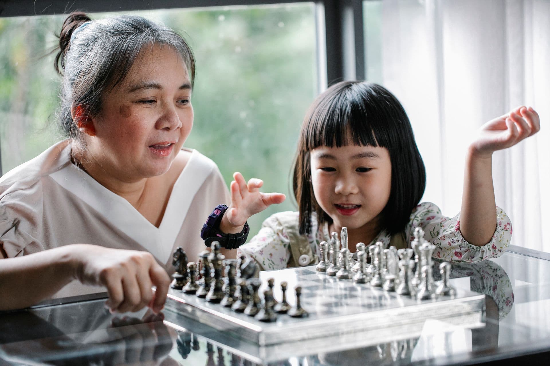A mentor and child playing a board game together indoors